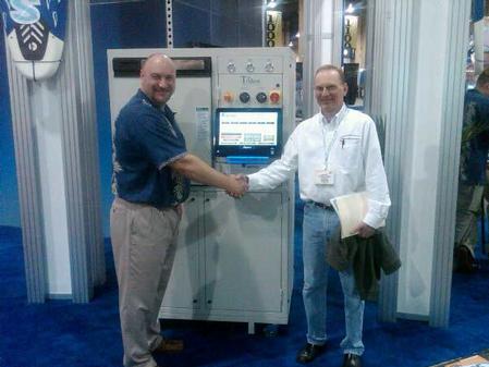 Aqueous Technologies Corp.’s Kevin Buckner (left) sold a Trident III to Bob Kajfasz of Advance Circuit Technology (right) during the recently held IPC/APEX Expo in Las Vegas.